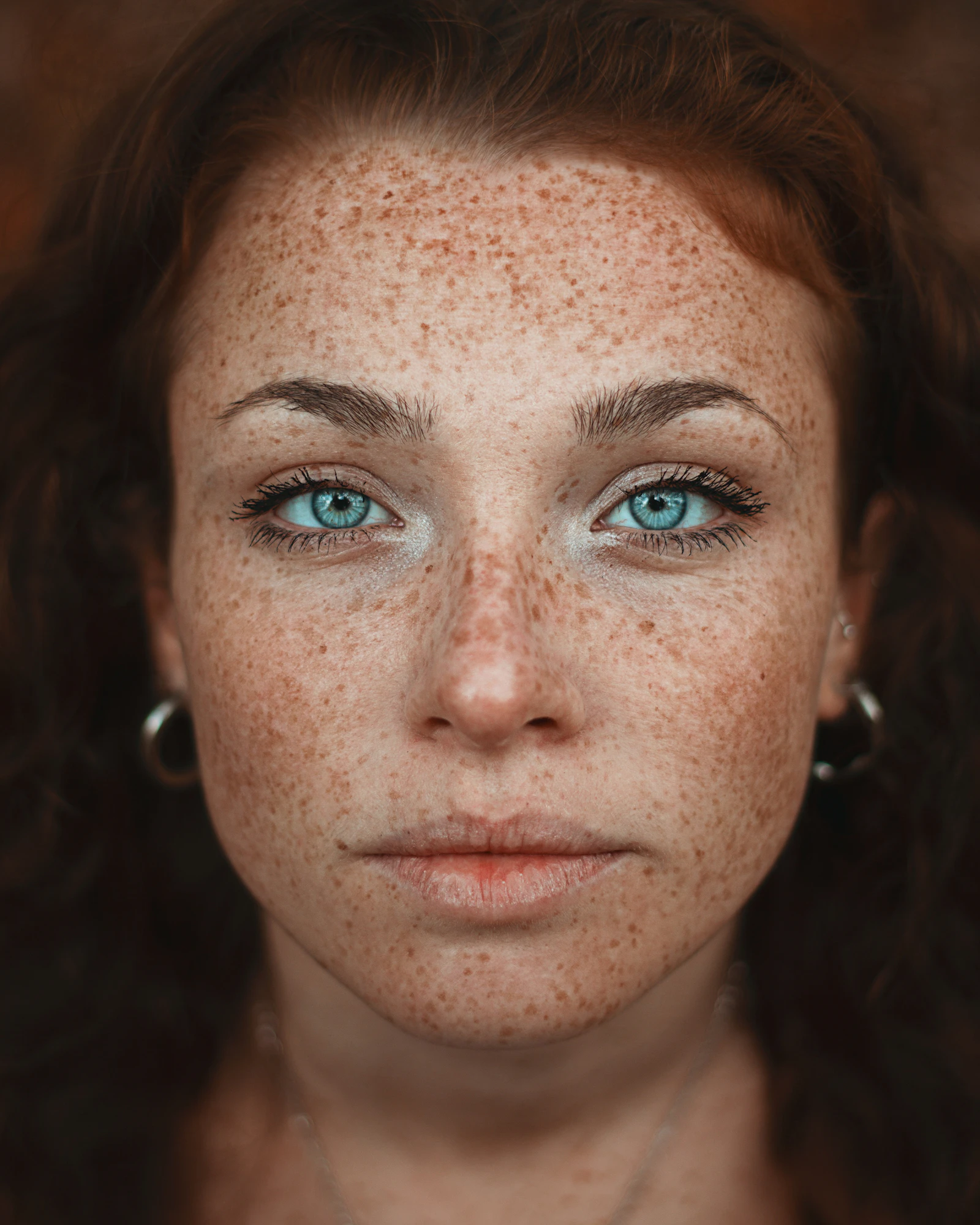 Woman with freckles and bare-looking skin photographed in soft daylight