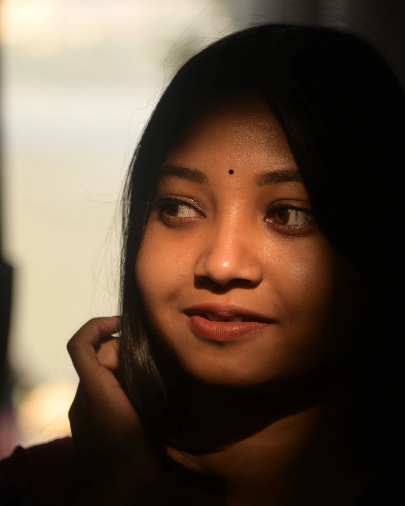 Woman wearing a bindi, turned toward warm evening light